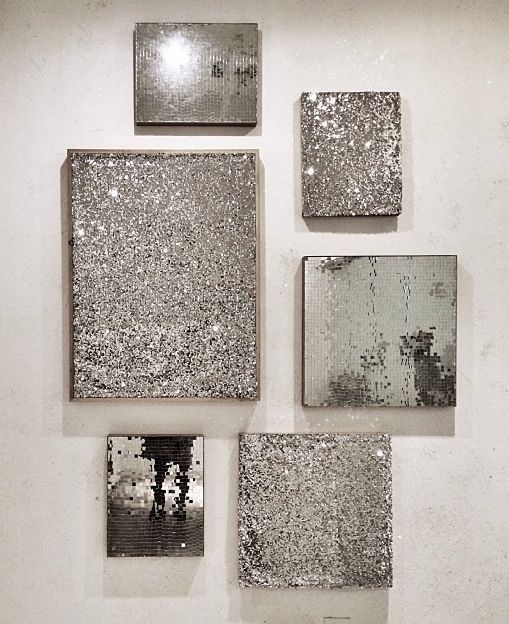 four square mirrors mounted to the side of a wall