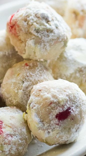 a white plate topped with powdered sugar covered donuts and cranberry sauce