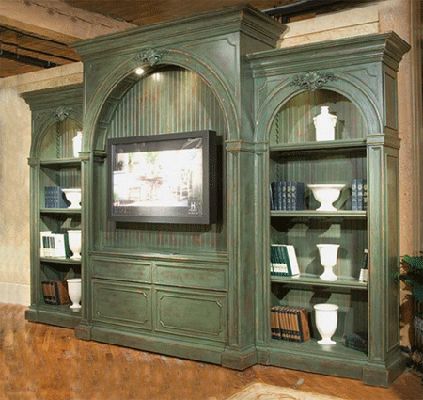 a large green entertainment center with bookshelves and vases on it's sides