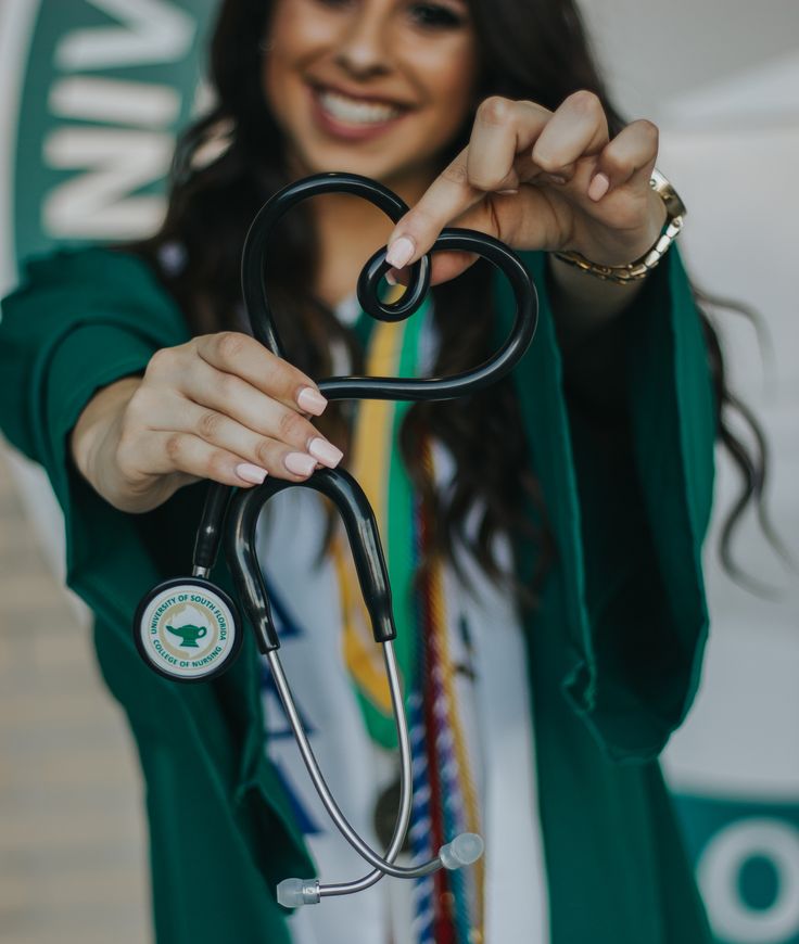 a woman holding a stethoscope up to her face and smiling at the camera