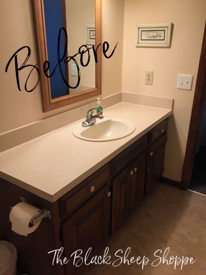 a bathroom with a sink, mirror and toilet paper dispenser in it