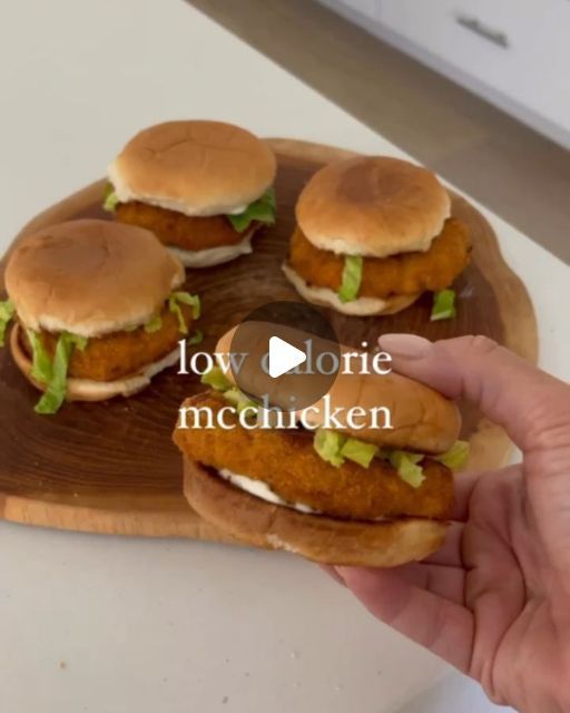 a hand holding a wooden tray with four sandwiches on it and the words low carb mchicken written in large letters