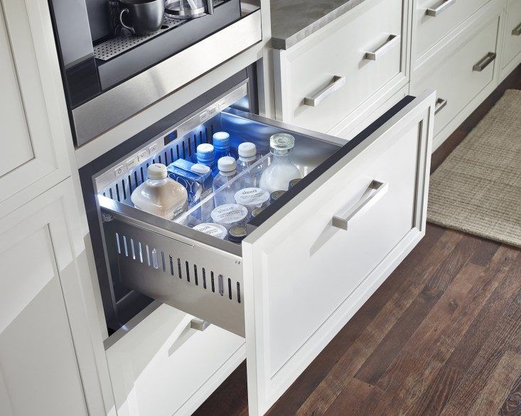 an open drawer in the middle of a kitchen