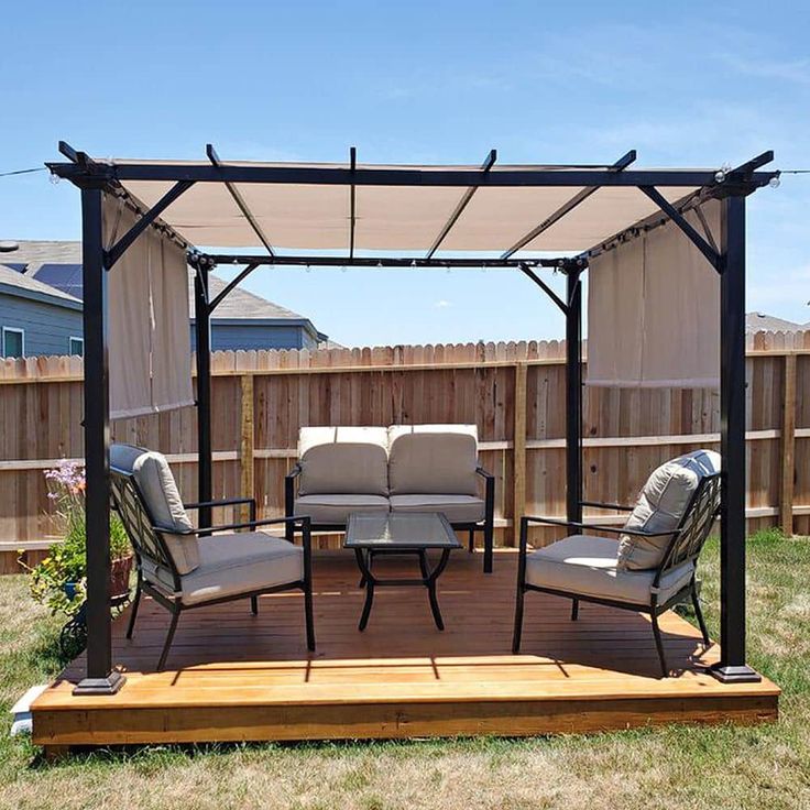 a gazebo sitting on top of a wooden deck next to a patio furniture set