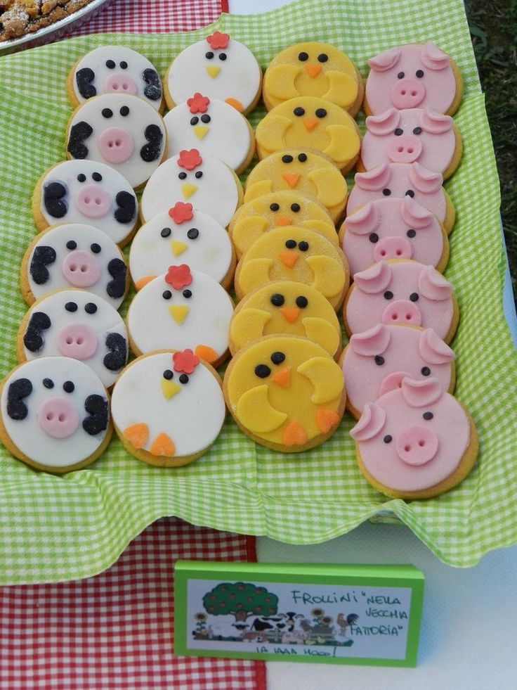 a table topped with lots of decorated cookies on top of a green and white checkered table cloth