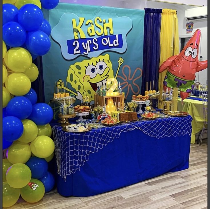 an under the sea themed birthday party with blue and yellow decorations, balloons and cake