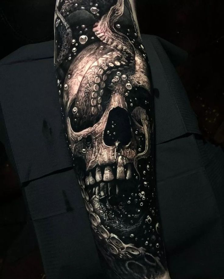 a man's arm with an octopus and skull tattoo on it