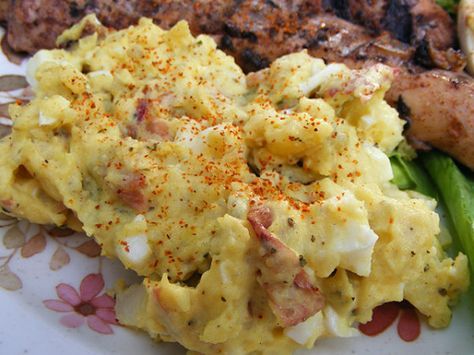 an omelet with meat and vegetables on a floral pattern plate is seen in this image