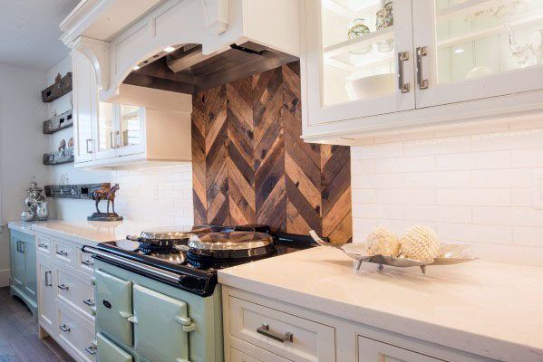 a stove top oven sitting inside of a kitchen next to white cabinets and counter tops