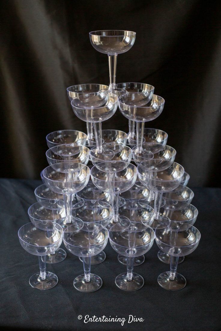 a stack of wine glasses sitting on top of each other in front of a black background