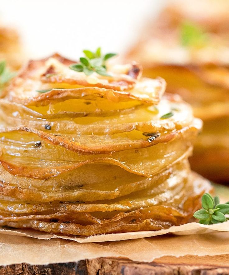 a stack of baked potatoes with herbs on top