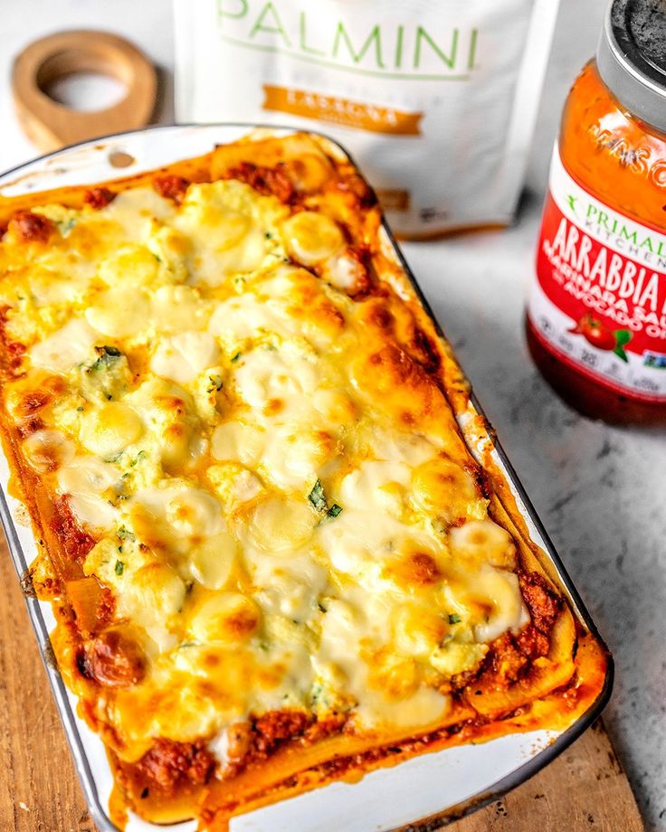 a casserole dish with cheese and broccoli next to some other ingredients