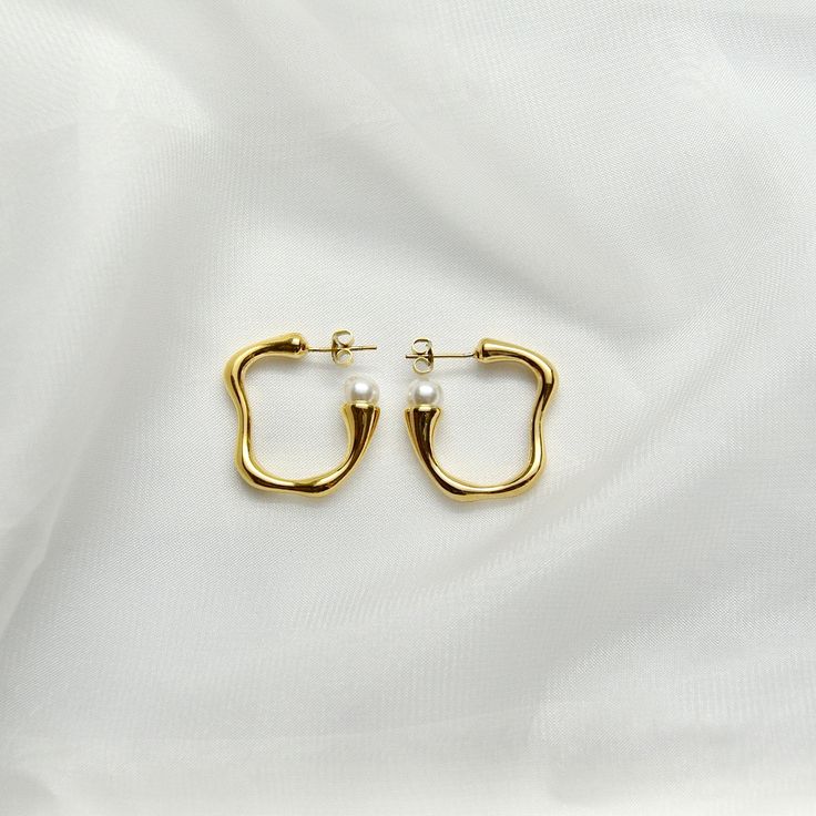 Pearl Hoop Earrings14K Gold Plated Stainless SteelOur Pearl Hoops are the perfect marriage of elegance and charm and will make a delightful addition to any jewelry collection. This lightweight accessory is minimalist in make, yet timeless in style. The unique pair is made with 14K Gold Plated Stainless Steel allowing its color to remain over time. It is accented with pearl impression.All of our products are lightweight and made with hypoallergenic materials to allow for comfortable, all day wear Classic Small Hoop Earrings In Recycled Gold, Elegant Recycled Gold Hoop Earrings, Modern Tarnish-resistant Hoop Earrings For Wedding, Formal Minimalist Brass Hoop Earrings, Brass Hoop Earrings For Wedding, Classic Hoop Earrings In Recycled Gold, Minimalist Hoop Pearl Earrings For Formal Occasions, Gold Minimalist Pearl Earrings, Tarnish Resistant, Elegant Small Hoop Huggie Earrings In Brass