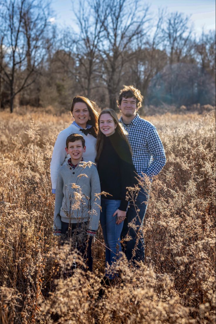 a family poses for a photo in the tall grass