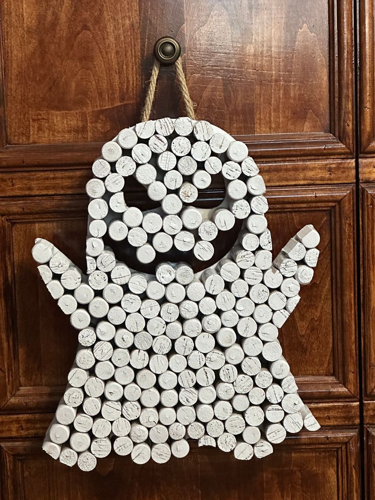 a door hanger made out of white wine bottle caps with a smiling face on it