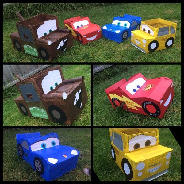 cars made out of cardboard boxes sitting in the grass