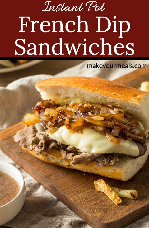 french dip sandwiches with cheese and onions on a cutting board