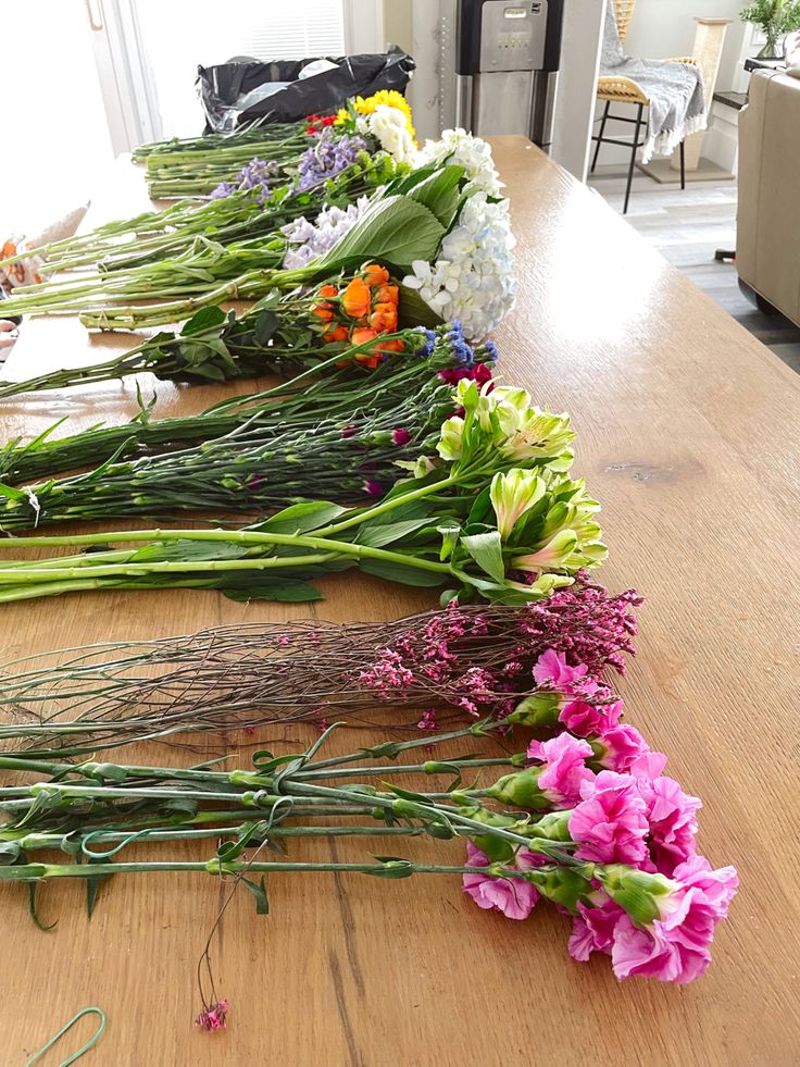 the flowers are laid out on the table ready to be placed in the vases