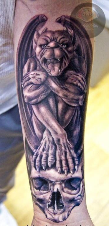 a man's arm with a tattoo on it that has an image of a demon hugging