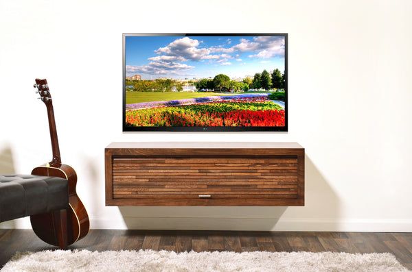 a flat screen tv sitting on top of a wooden cabinet in front of a guitar