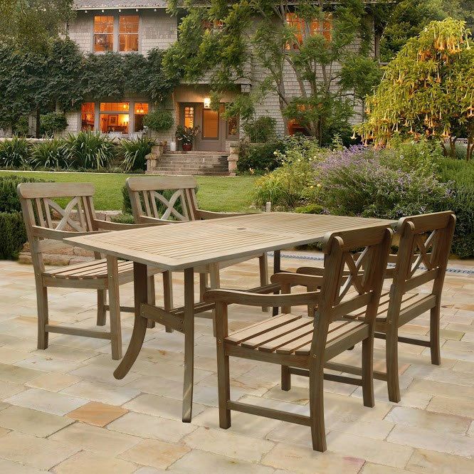 a wooden table and chairs on a patio