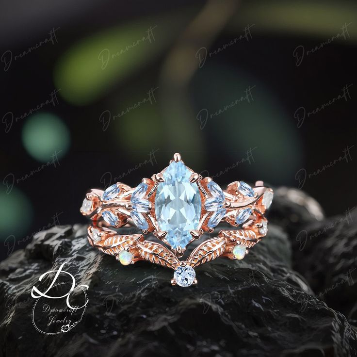 an engagement ring with blue topazte surrounded by diamonds on a rock in front of blurry background