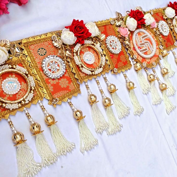 a table topped with lots of tassels and flowers on top of white cloth