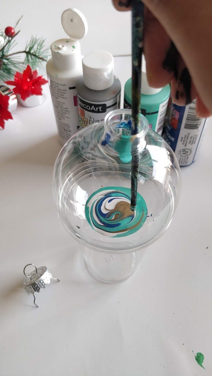 someone is painting the inside of a glass bowl with acrylic paint on it