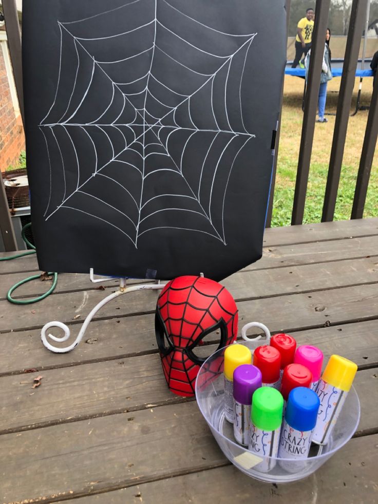 a spiderman chalkboard and markers on a deck