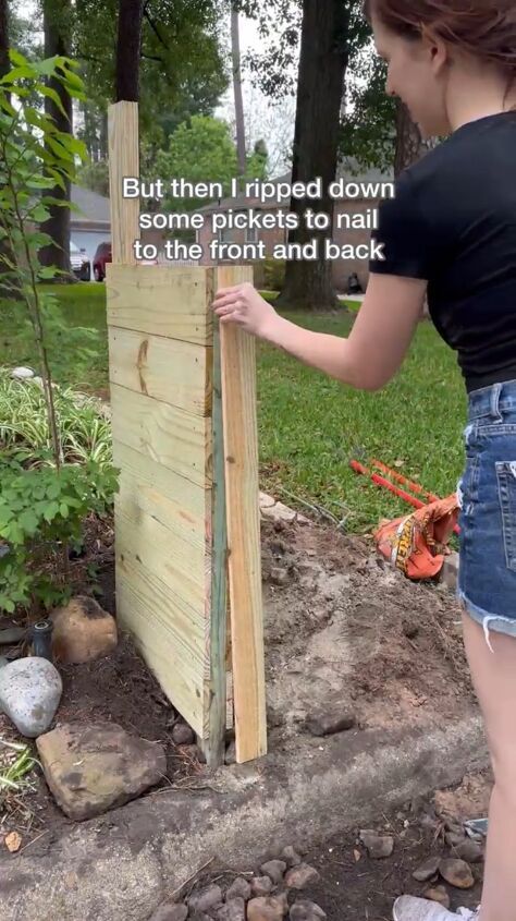 a woman is placing wood on the side of a wooden fence to make it look like she's about to fall in love with someone