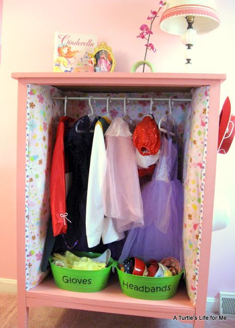 a pink cabinet with clothes hanging on it