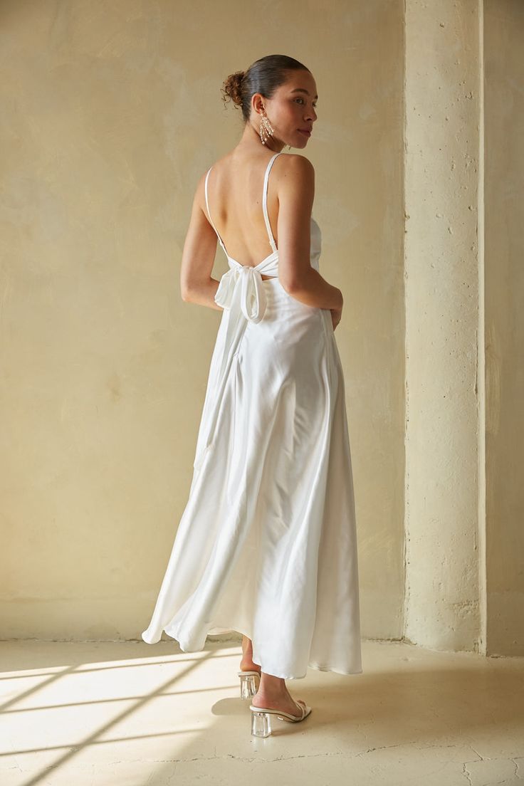 Say "I do" to the romantic Mary Bow Back Satin Maxi Dress. This white satin maxi dress features a v-neckline, open back, and bow detailing that makes this style irresistible. Style with some chic jewelry to add the finishing touch! Details Self: 98% Polyester, 2% Spandex Lining: 88% Polyester, 12% Spandex Back ZipperMaterial has minimal stretch Adjustable spaghetti straps Side bodice boning Hand wash cold / Hang dry Feminine Satin Maxi Dress For Brunch, Satin Backless Dress With Tie Back For Brunch, Satin Midi Dress With Tie Back For Brunch, Chic Sleeveless Maxi Dress For Wedding Night, Feminine Backless Dresses For Wedding Night, White Silk Maxi Dress For Wedding Night, Chic Maxi Dress For Wedding Night, Elegant White Maxi Dress For Wedding Night, Wedding Backless Dress With Tie Back