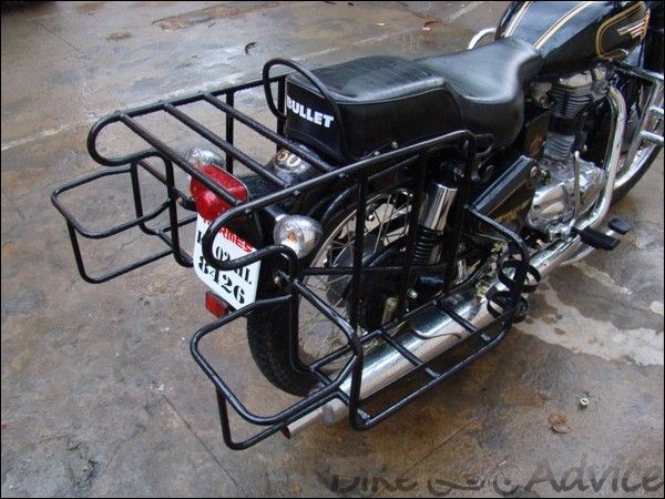 a black motorcycle with a metal basket on it's back end and the handlebars still attached