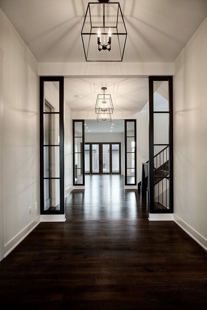 an empty room with wood flooring and glass doors leading to the second story area