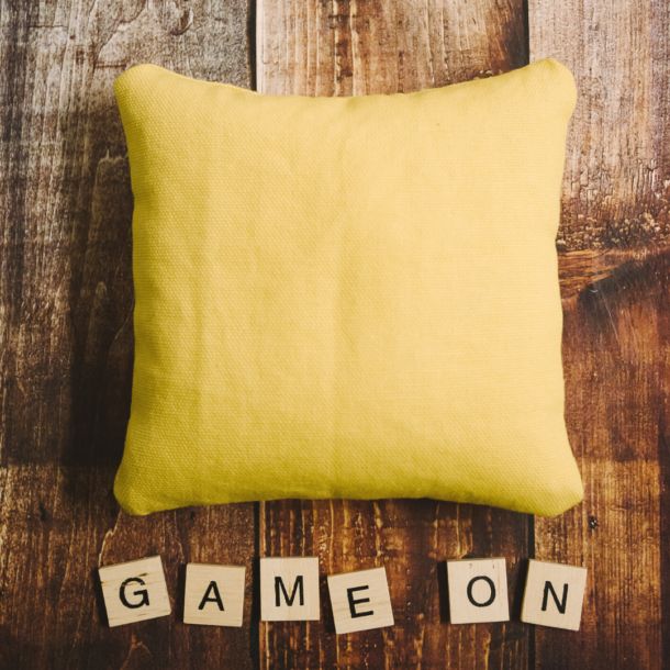 the word game on spelled out with scrabbles in front of a yellow pillow