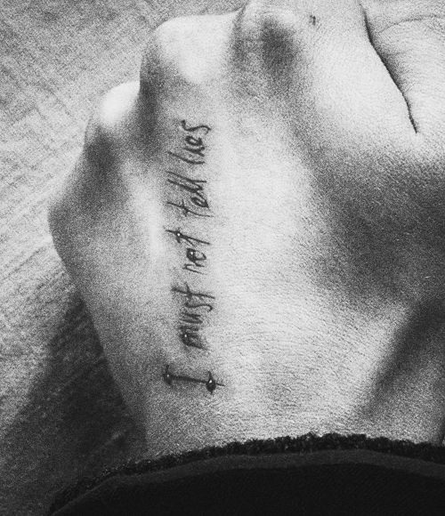 a black and white photo of a person's wrist with the word strength on it