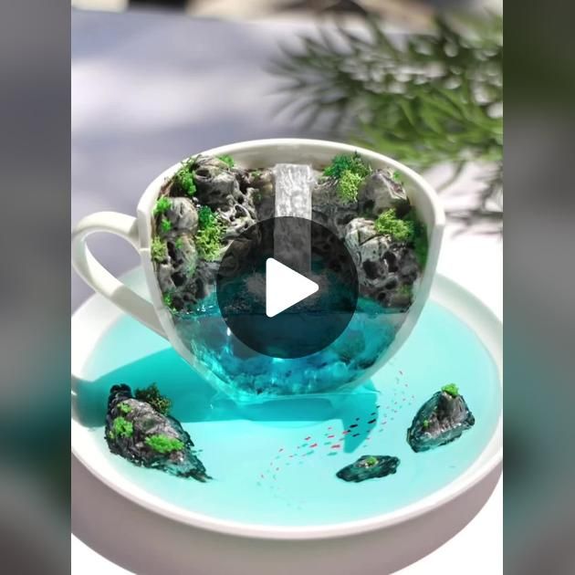 a cup filled with water and rocks on top of a plate