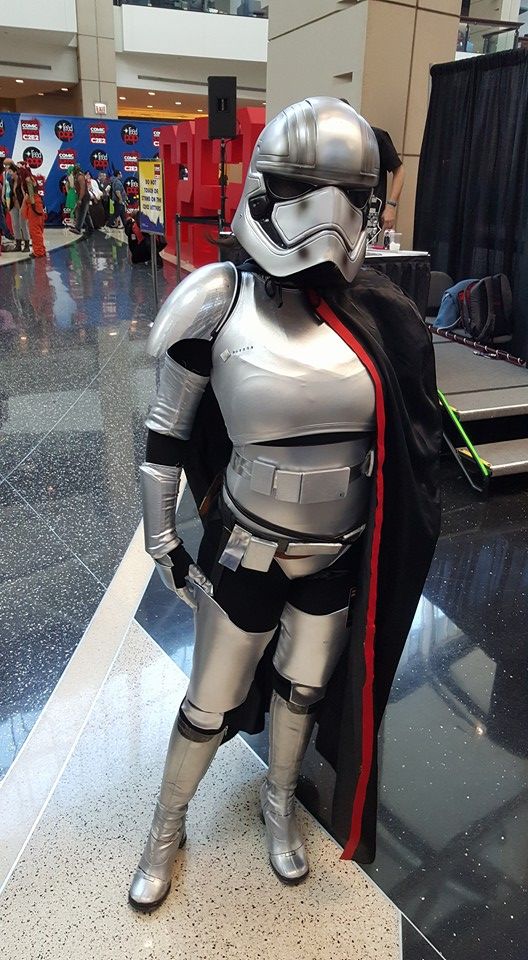 a man in a star wars costume standing next to a luggage carousel at an airport