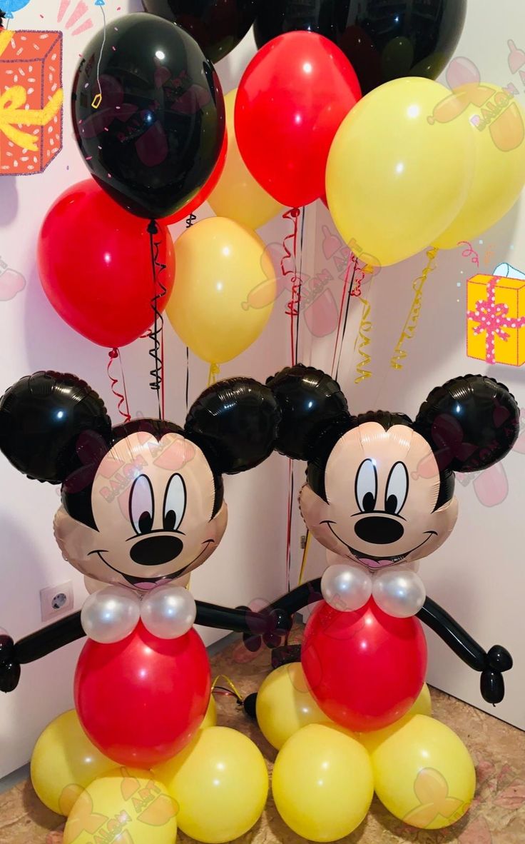 mickey and minnie mouse balloons in front of a wall