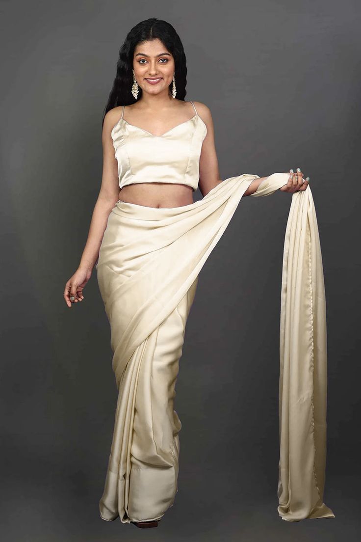 Experience the epitome of elegance with our Tia Cream Monochrome Cream One Minute Saree, crafted from luxurious satin fabric. Wear this luxurious saree for your next event or adorn your besties in this as the perfect Bridesmaid's saree! The saree's rich texture and delicate drape create a mesmerizing silhouette that exudes grace and sophistication. Perfect for special occasions or festive celebrations, this saree adds a timeless charm to your ensemble, making you the center of attention. Product Elegant Silk Pre-draped Saree For Festive Occasions, Diwali Evening Art Silk Pre-draped Saree, Festive Satin Pre-draped Saree, Bollywood Style Silk Evening Sets, Elegant Silk Pre-draped Saree For Diwali, Elegant Formal Art Silk Pre-draped Saree, Festive Satin Pre-draped Saree For Formal Occasions, Elegant Evening Sets For Diwali, Elegant Fitted Katan Silk Pre-draped Saree