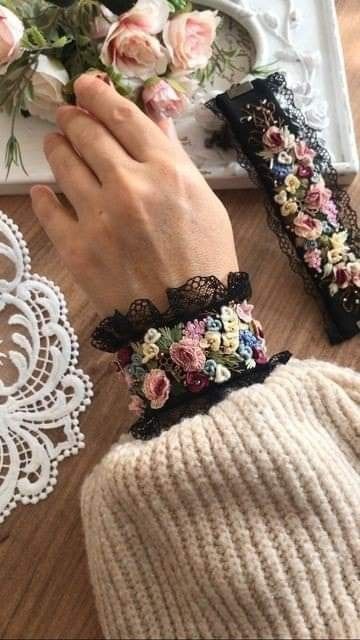 the woman is wearing two bracelets with flowers on them and lace around her wrist