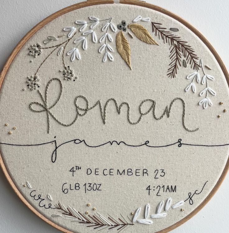 a embroidery project with the name roman written in cursive writing, surrounded by flowers and leaves