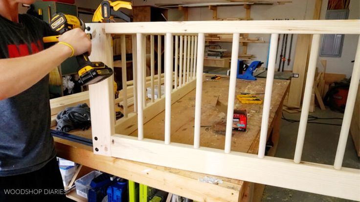 a man is working on a wooden railing