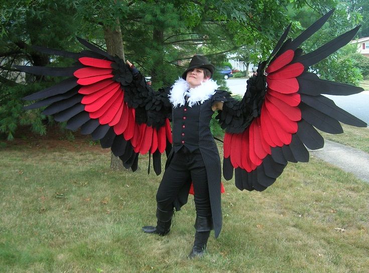 a man dressed in black and red with large wings