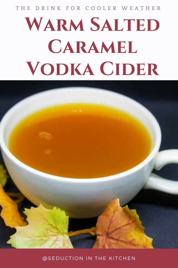 the drink for cold weather caramel vodka cider is in a white bowl with leaves around it