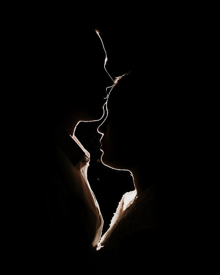 two people are kissing in the dark