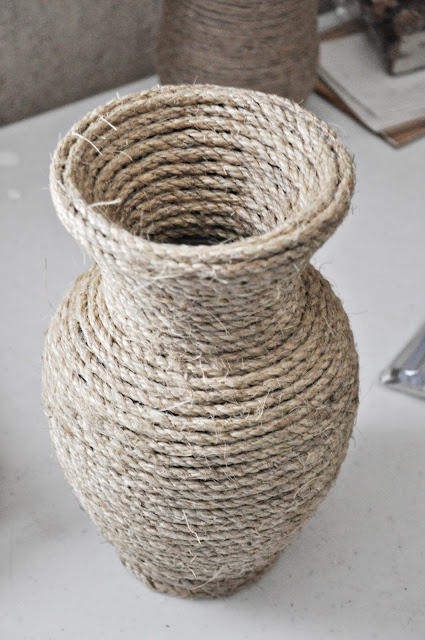 a close up of a vase on a table with rope wrapped around the top and bottom