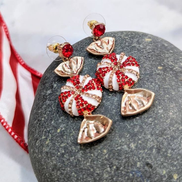 Holiday Sparke Red White Peppermint Dangle Post Earrings Christmas These Gorgeous Dangle Earrings Are The Perfect Way To Dress Your Ears For Holiday Parties, Shopping Trips Or Just Wear Any Time You're In The Spirit! They Also Make A Great Stocking Stuffer Or Secret Santa Gift! Red Gem At The Top From Post With Gold-Tone "Wrapper" And Sparkly Gem Studded Peppermint. Measures Approximately 2 Inches Long. Includes Backs With Plastic Disks To Stabilize Earrings On The Ears. Lead And Cadmium Complia Pink Christmas Party Jewelry, Red Christmas Earrings For Holiday, Red Earrings For Christmas Holiday, White Christmas Jewelry For Festive Season, White Christmas Jewelry For Holidays, White Christmas Jewelry For Festive Occasion, White Christmas Festive Jewelry, White Festive Jewelry For Christmas, White Holiday Dangle Jewelry