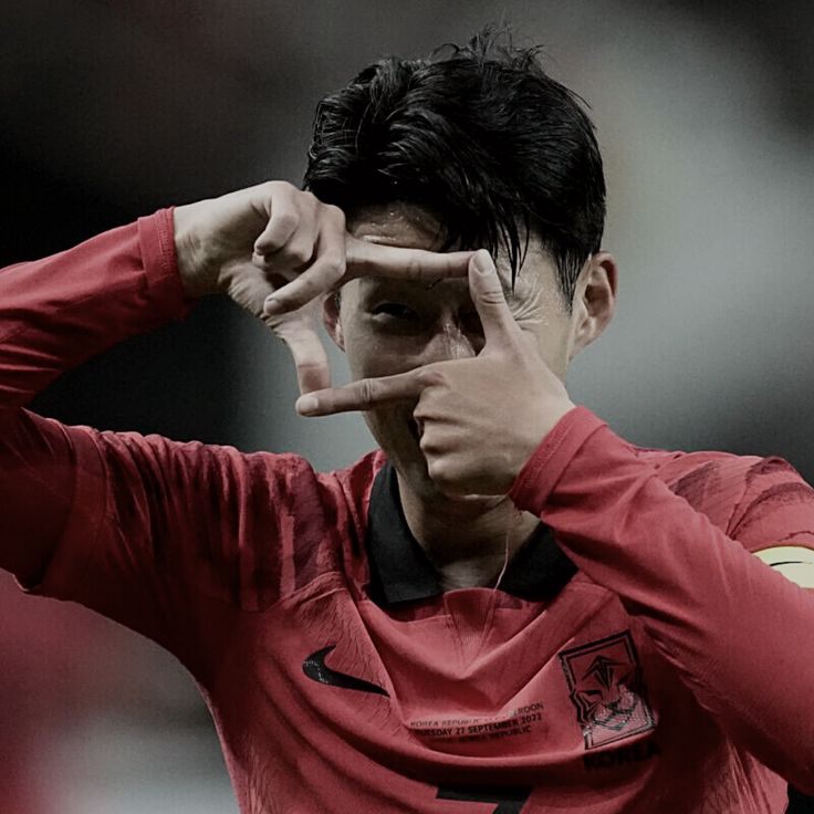 a soccer player is making the peace sign with his fingers