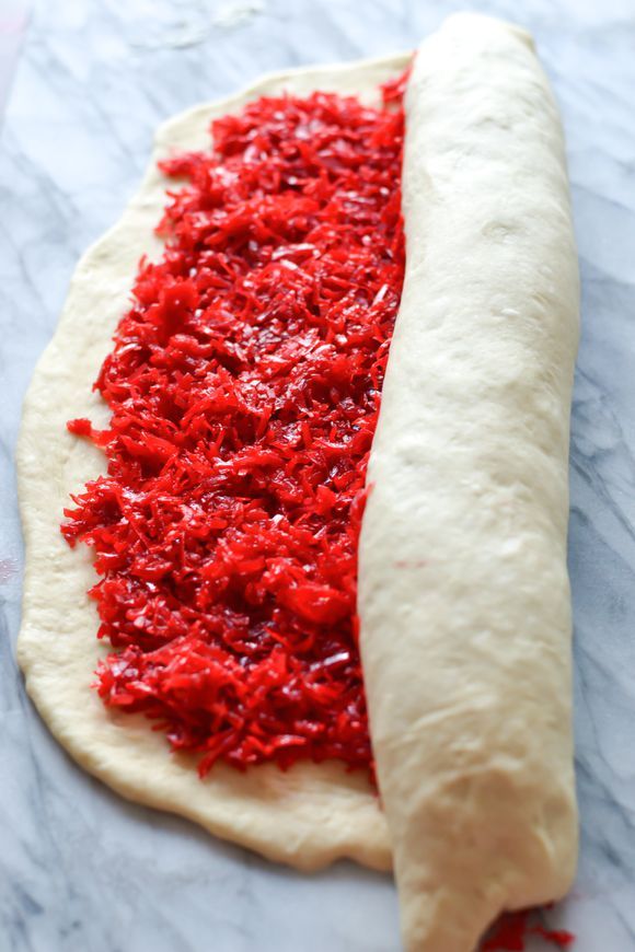 a long piece of bread with red stuff on it sitting on top of a table